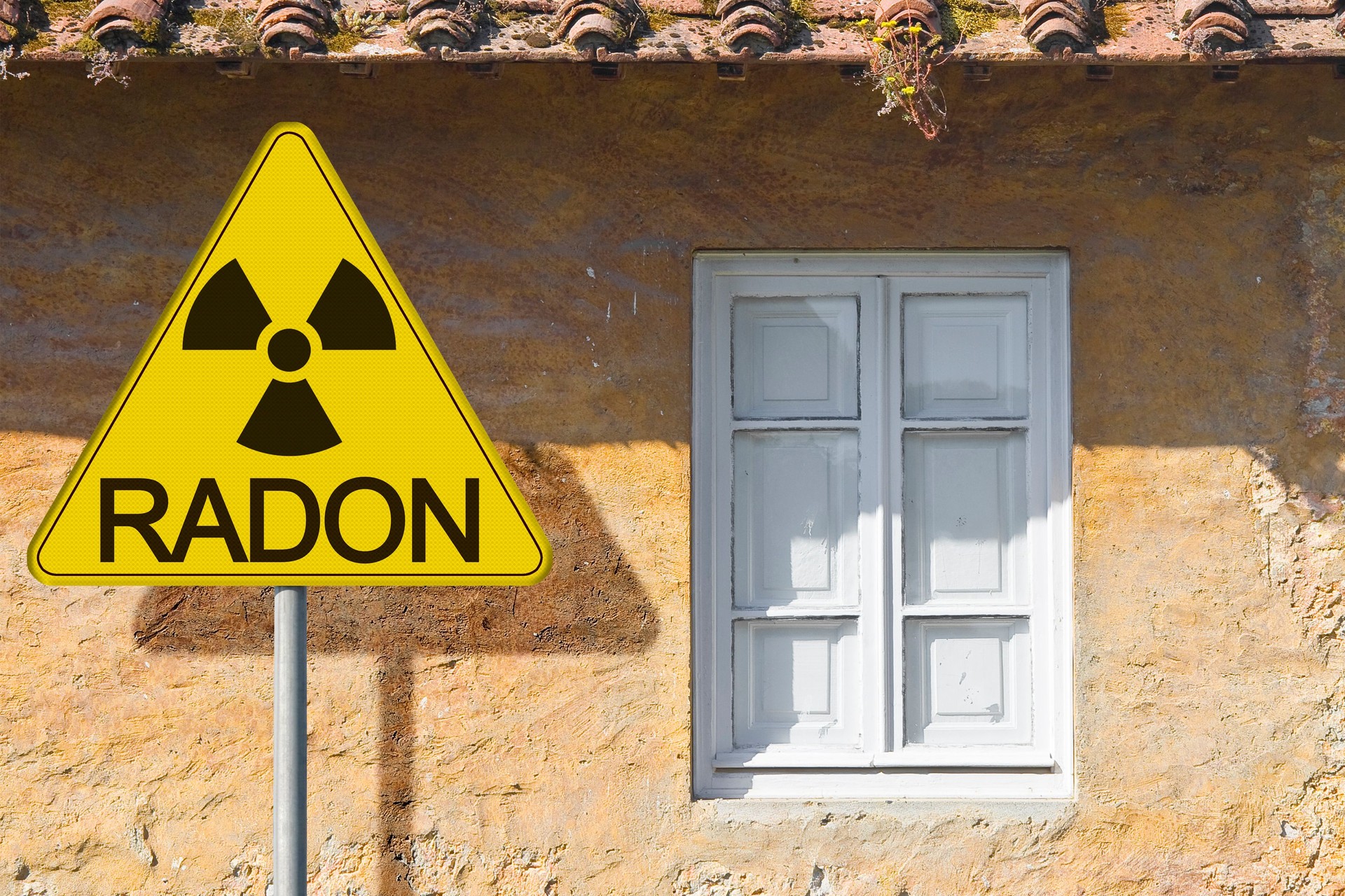 THE DANGER OF RADON GAS IN OLD BUILDINGS - Concept with signboard against an old residential window